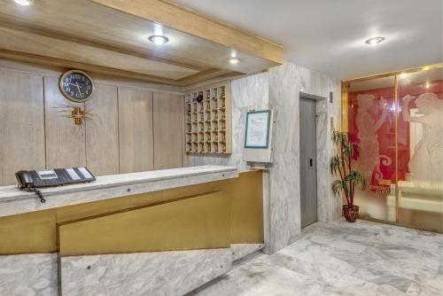 a hotel lobby with a reception desk and a clock at Hotel Halaris in Ermoupoli