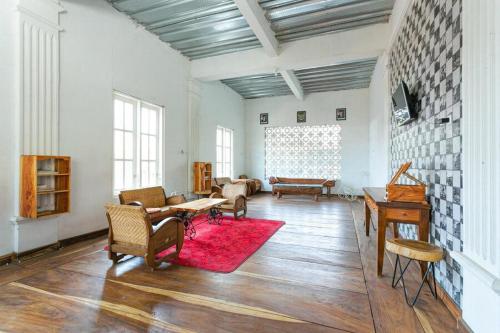 a living room with a red rug on a wooden floor at RedDoorz near Grojogan Sewu Tawangmangu in Karanganyar