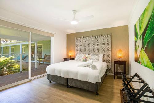 a bedroom with a large bed and a balcony at Nelson's Landing - Pet Friendly in Jervis Bay in Vincentia