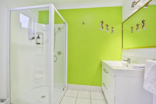 a green bathroom with a shower and a sink at Nelson's Landing - Pet Friendly in Jervis Bay in Vincentia
