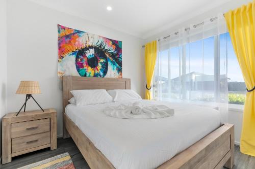 a bedroom with a bed and a large window at OSPREY ISLAND RETREAT in Banksia Beach