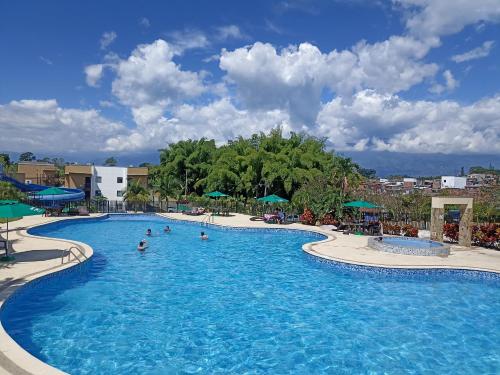 una piscina en un complejo con gente dentro en Hermosa vista - Wifi gratis - Refugio del Edén Apartasol, en La Tebaida