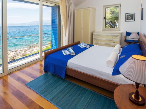 a bedroom with a bed with a view of the ocean at Villas Violet & Rosemary in Supetar