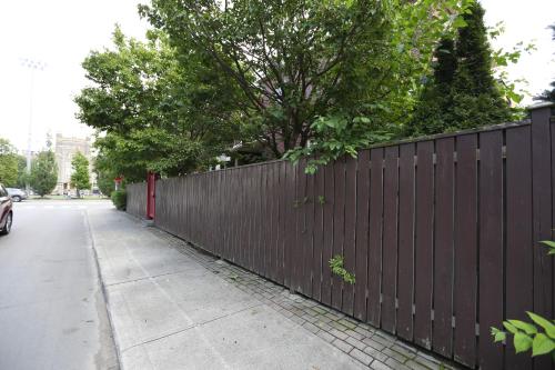 a fence on the side of a sidewalk next to a street at Phoebe Wang in Toronto