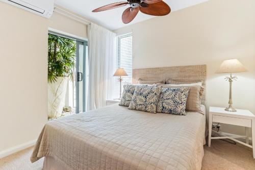 a bedroom with a bed with a ceiling fan at Beachfront luxury, Hastings Street in Noosa Heads