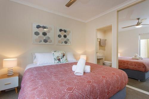 a bedroom with a bed and a mirror in it at Casa Toucan - 2 bedroom apartment close to the airport in Perth