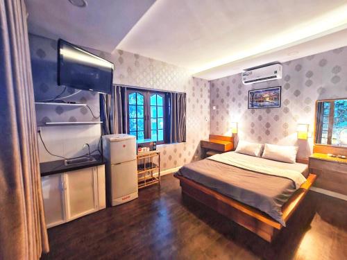 1 dormitorio con 1 cama y TV en Cactusland Villa Near Bui Vien Street, en Ho Chi Minh