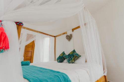 1 dormitorio con 1 cama blanca con dosel en UUTTAAKA Eco-Hotel en Palomino