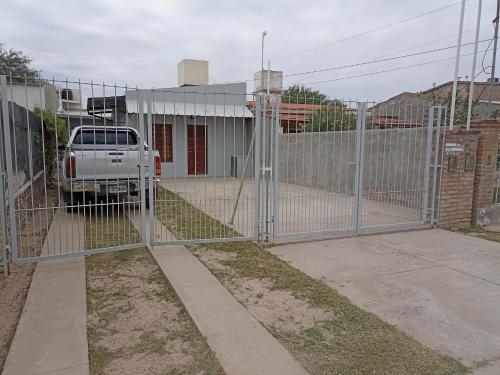 een poort voor een gebouw met een vrachtwagen erachter bij Atardecer Santiagueño in Fernández