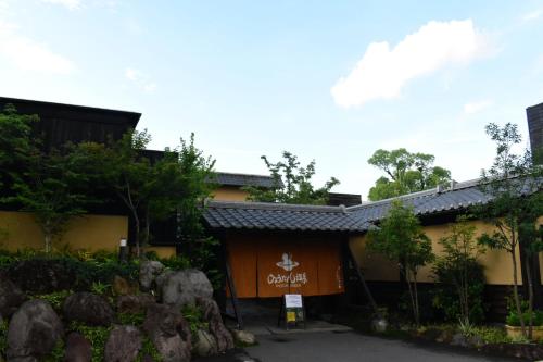 a building with a sign on the side of it at OMOLOSO Hostel　オモロソウ ホステル in Beppu
