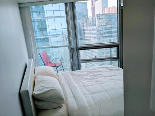 a bedroom with a bed and a large window at ICE Condominiums in Toronto