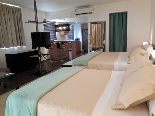 リオ・アトにあるPlaya Blanca Town Centerのベッド2台とテレビが備わるホテルルームです。