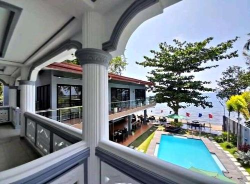 uma vista a partir de uma varanda de uma casa com piscina em Baki Divers and Beach Resort em Dauin