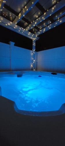 a room with a blue pool of water with lights at Hot tub- 80's Arcade- Pool table- Historic Downtown- 7 car parking in St. Augustine