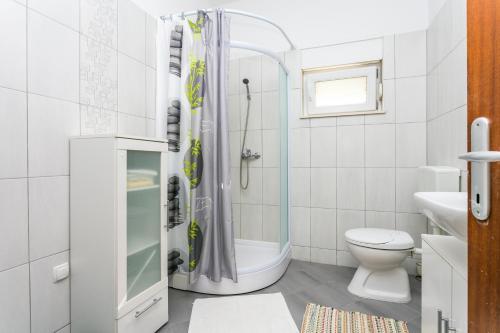 a white bathroom with a shower and a toilet at Apartments by the sea Kastel Stafilic, Kastela - 21145 in Kaštela