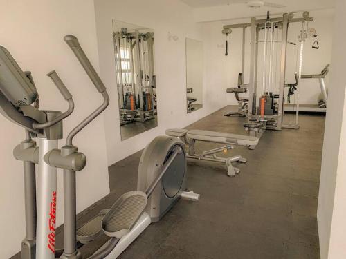 a gym with several treadmills and machines at MaSa Beach Front Apartment Uswetakeiyawa in Ja-Ela