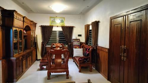 una sala de estar con sillas y muebles de madera. en La maison de Soriya - Work & Stay en Kampot