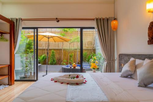 um quarto com uma grande cama branca e um guarda-chuva em Angkor Rithy Boutiques em Siem Reap