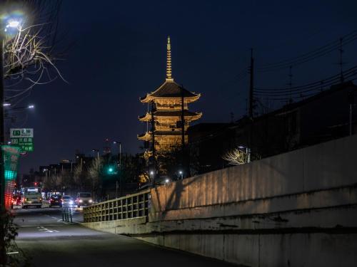 a pagoda in the middle of a city at night at HALE Kyoto Toji#Tabist in Kyoto
