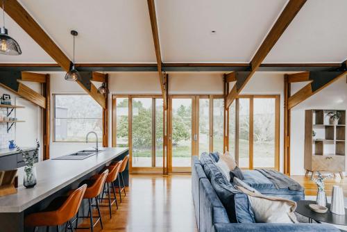 a kitchen and living room with a blue couch at Park Crescent - Daylesford Macedon Region in Kyneton