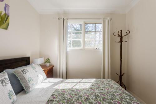 a bedroom with a bed and a window at Nilgiri 3BR Mountain Retreat 5mins Katoomba Centre in Katoomba