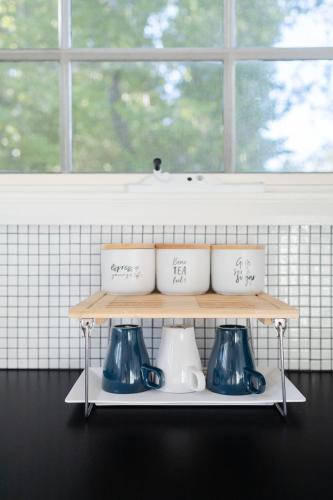 a shelf with three vases on it in front of a window at Nilgiri 3BR Mountain Retreat 5mins Katoomba Centre in Katoomba