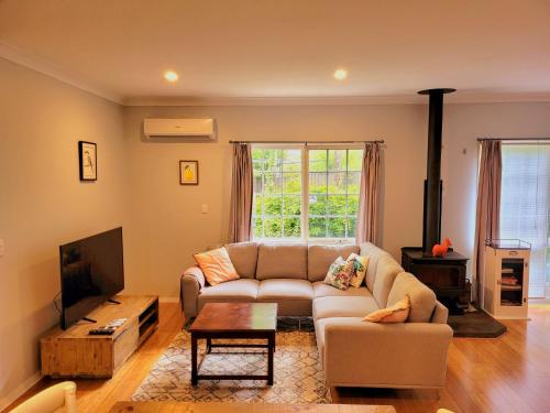 a living room with a couch and a tv at Nilgiri 3BR Mountain Retreat 5mins Katoomba Centre in Katoomba