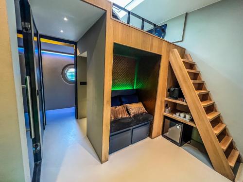 アムステルダムにあるBoat & Boost Amsterdamの二段ベッドと階段が備わる小さな客室です。