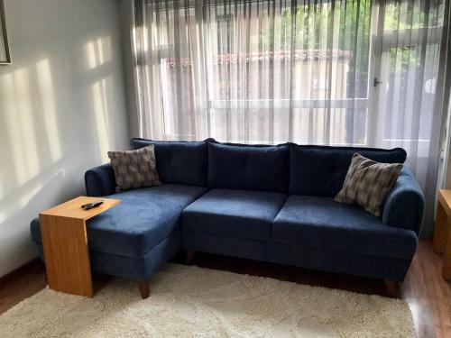 a blue couch in a living room with a window at Cozy and Modern Flat Near Bosphorus At Arnavutköy in Istanbul