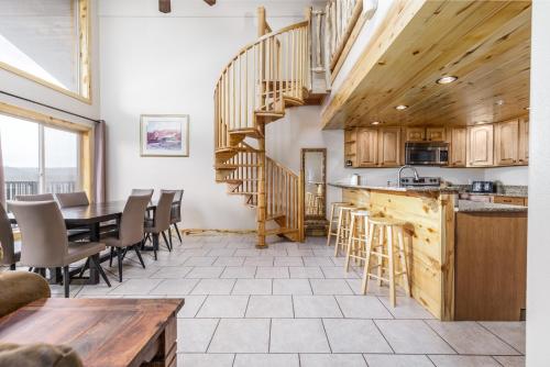 a kitchen and dining room with a wooden spiral staircase at The Lodge at Duck Creek in Duck Creek Village