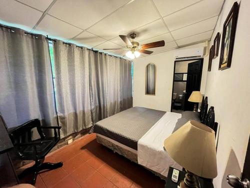 1 dormitorio con 1 cama y ventilador de techo en San Diego Beach House, near La Lib and Surf City en La Libertad