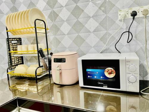 a microwave sitting on a counter next to a blender at Goodvibes#HomeNearSenaiAirport#Aeon#IOI in Kulai