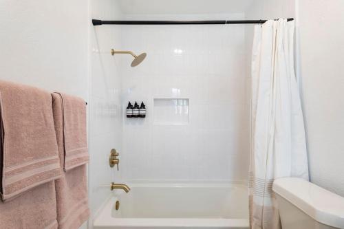 a white bathroom with a shower and a sink at 2 Bedroom East Riverside Home with Garage-Sleeps 6 in Austin