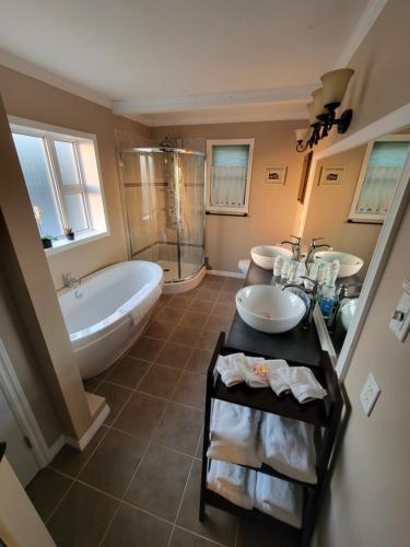 La salle de bains est pourvue de 2 lavabos et d'une baignoire. dans l'établissement Bluejay Suites B&B, à Whitehorse