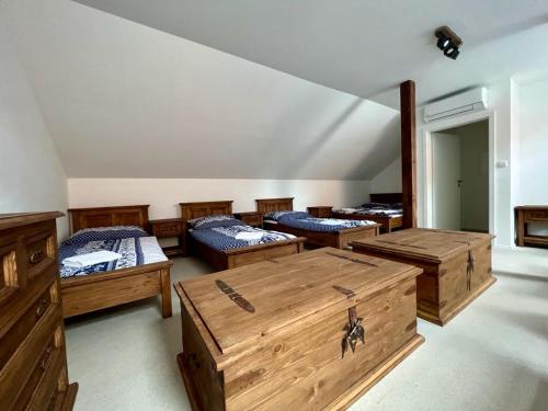 ミクロフにあるPension Mikulovのベッド4台と木製の胸が備わる客室です。