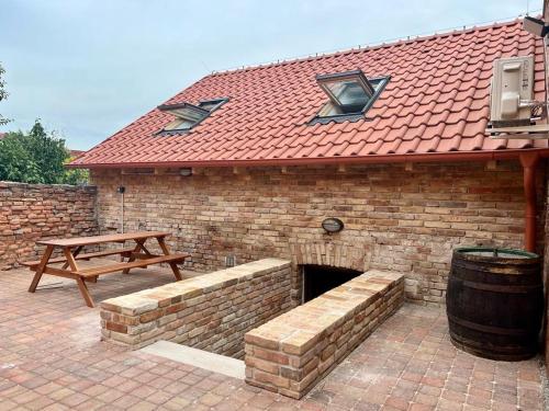 a brick building with a bench and a picnic table at Pension Mikulov in Mikulov