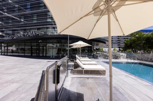 a swimming pool with lounge chairs and an umbrella at Crowne Plaza - Marseille Le Dôme in Marseille