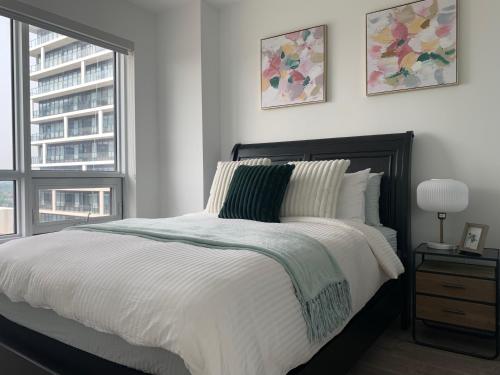 a bedroom with a bed and two windows at QQ MARKHAM condo in Markham