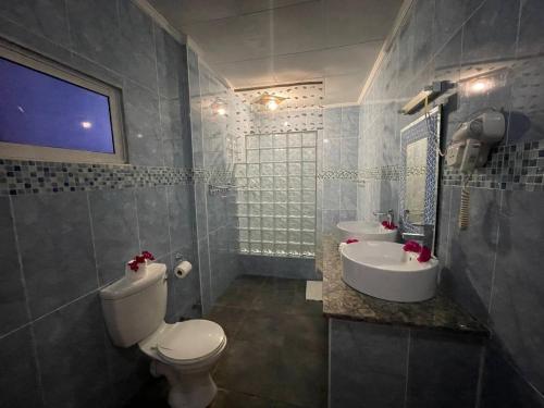 a bathroom with a toilet and a sink at Villa Authentique in La Digue