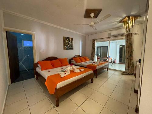 ein großes Schlafzimmer mit 2 Betten und einem Balkon in der Unterkunft Villa Authentique in La Digue