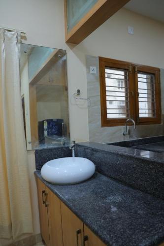 a bathroom counter with a sink and a mirror at Padma Homes Stay- Luxury Service Apartment 1BHK & 2BHK & 3BHK in Tirupati