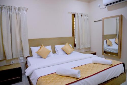 een slaapkamer met een groot bed en een grote spiegel bij Padma Homes Stay- Luxury Service Apartment 1BHK & 2BHK & 3BHK in Tirupati