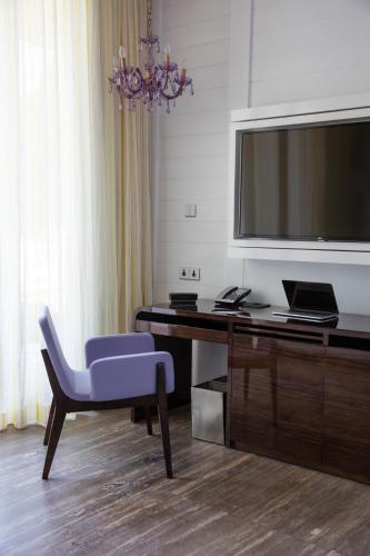 a room with a desk with a tv and a blue chair at W Goa in Vagator
