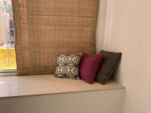 three pillows sitting on a window sill in a room at Mon Desire 1, Perry Cross Rd, Bandra West by Connekt Homes in Mumbai
