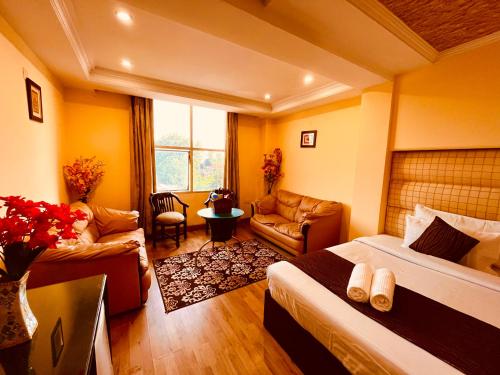 Habitación de hotel con 2 camas y sala de estar. en Rio Classic, Top Rated & Most Awarded Property in Haridwar, en Haridwar