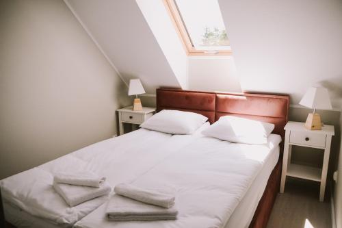 1 dormitorio con 1 cama con sábanas y almohadas blancas en Szklany Przystanek en Kościerzyna