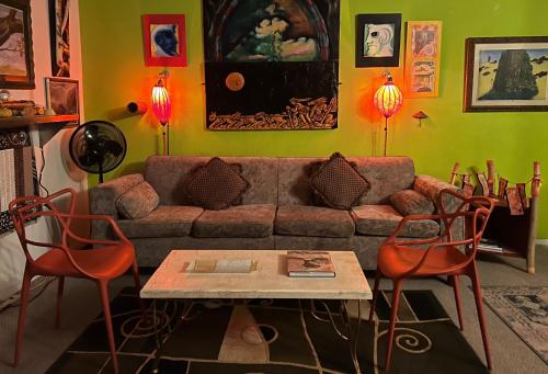 a living room with a couch and a table and chairs at SPACE CASTLE: a 1950s Gas Station transformed into an Art Themed Wonderland in Truth or Consequences