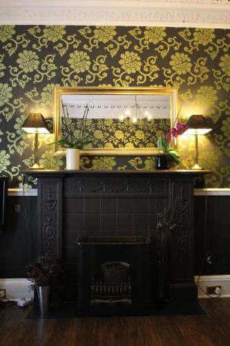 a living room with a fireplace and a mirror at The Sandaig in Edinburgh