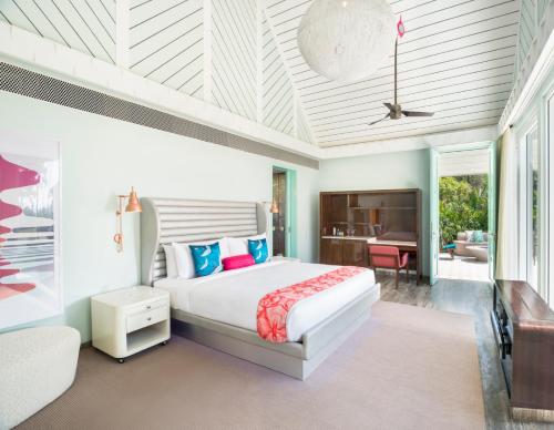 a bedroom with a large bed and a desk at W Goa in Vagator