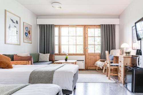 een hotelkamer met 2 bedden en een bank bij Hotel Kuusamon Portti in Kuusamo